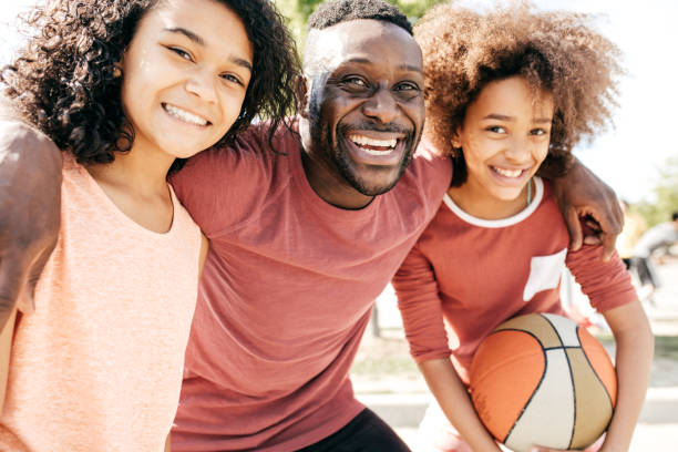 istock Dad and daughters  posing with basketball ball 837829222