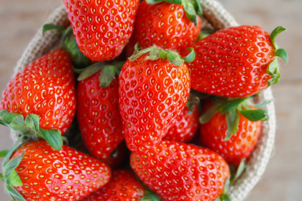 istock strawberries in small sack on wooden table background 837834794
