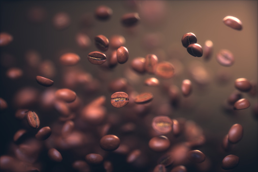 Roasted coffee beans, frozen grain in the air with shallow depth of field.