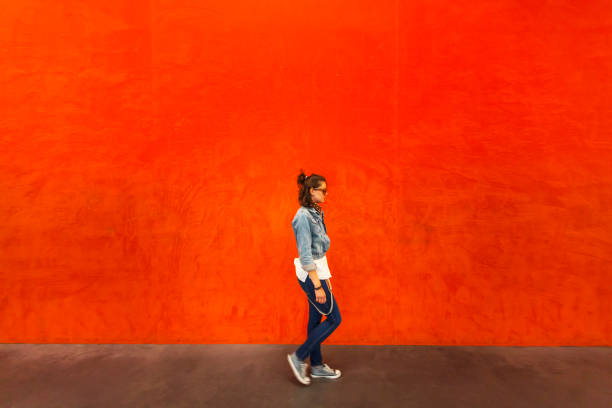 istock Woman walking in front of red background 837848222
