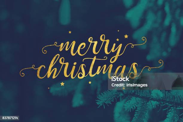 Merry Christmas Script With Evergreen Branches Background Stock Photo - Download Image Now