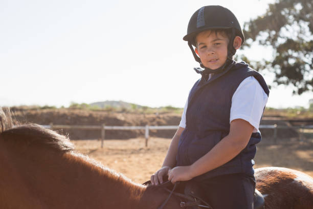 istock Boy riding a horse in the ranch 837939212