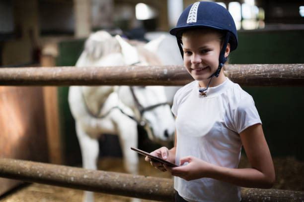 istock Teenage girl using digital tablet in the stable 837968402