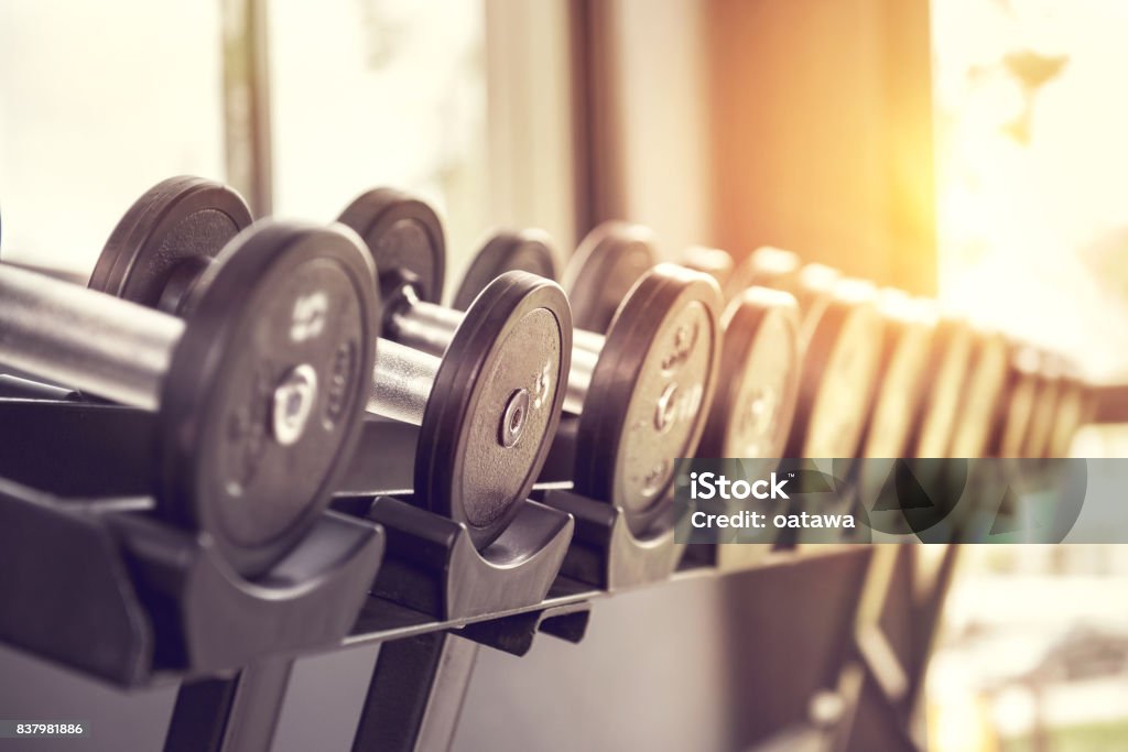 Rows of dumbbells in the gym with sunlight. Rows of dumbbells in the gym with sunlight in morning. Gym Stock Photo