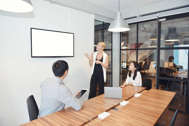Business blonde woman presenting a project on blank screen TV