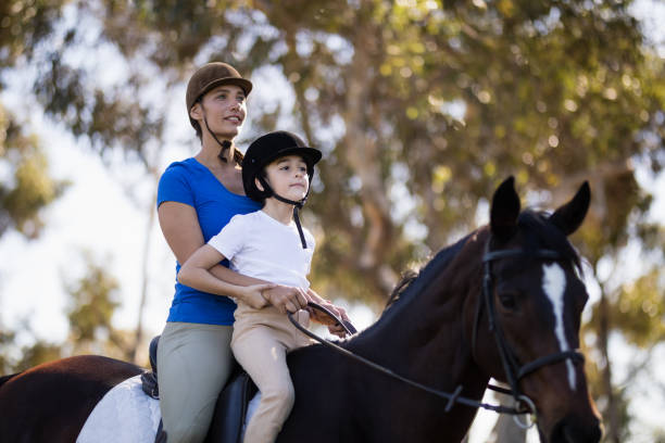 donna che insegna equitazione alla ragazza - teaching child horseback riding horse foto e immagini stock