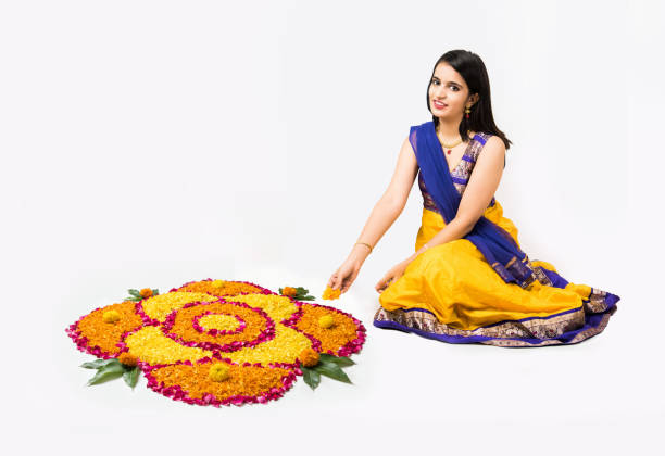 Indian woman or young girl making floral or flower rangoli for diwali or onam, isolated over white background Indian woman or young girl making floral or flower rangoli for diwali or onam, isolated over white background diwali stock pictures, royalty-free photos & images