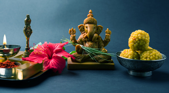 Happy Ganesh Chaturthi Greeting Card showing photograph of lord ganesha idol, pooja or puja thali, bundi laddu/modak, durva and hibiscus or jasvand flower