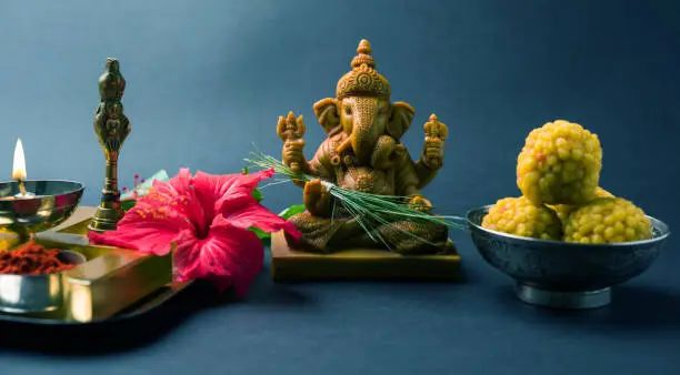 Happy Ganesh Chaturthi Greeting Card showing photograph of lord ganesha idol, pooja or puja thali, bundi laddu/modak, durva and hibiscus or jasvand flower