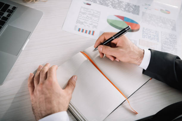 istock close-up shot of businessman writing in notebook 838024004
