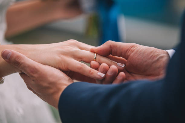 istock Newlyweds exchange rings, groom puts the ring on the bride's hand. 838032994