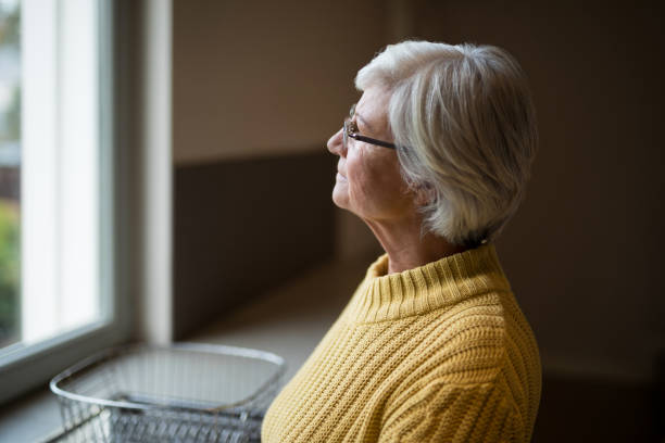 istock Thoughtful senior woman looking through kitchen window 838033434