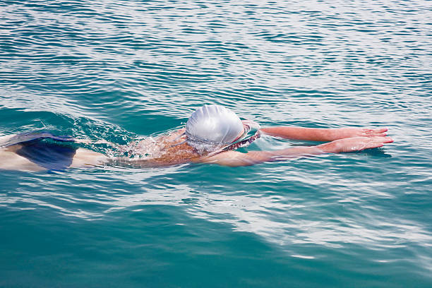 swimmer half submerged powering forward  - 13427 imagens e fotografias de stock