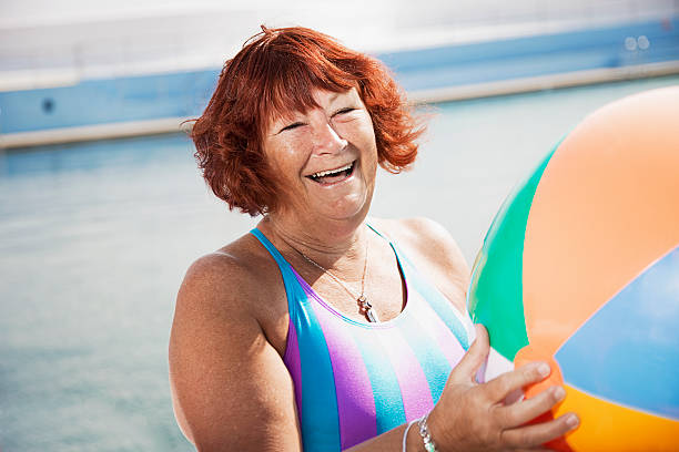 woman laughing holding a beach ball  - 13427 fotografías e imágenes de stock