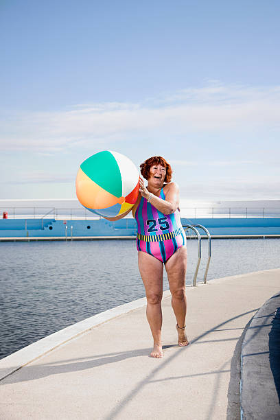 woman at the side of a pool with a beach ball   - 13427 fotografías e imágenes de stock