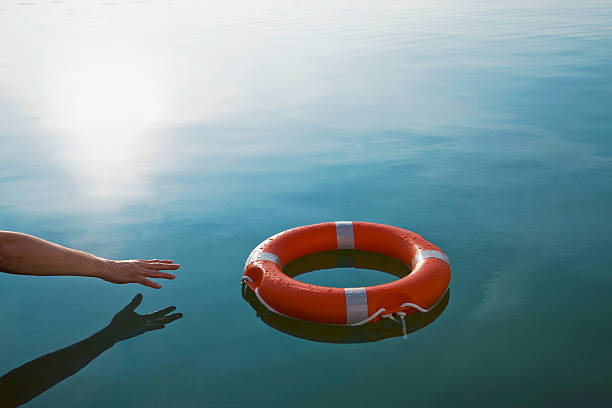 someone reaching out for a life-ring  - water crisis photos et images de collection