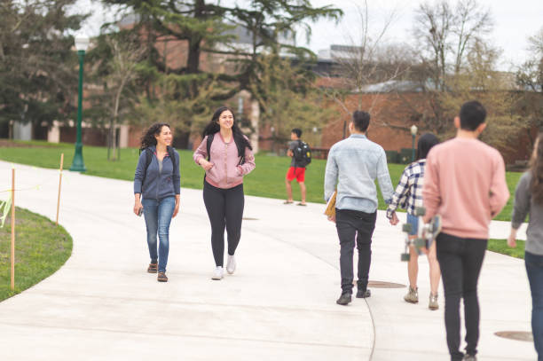 istock College students hang out in between classes on sidewalk, talking and smiling 838036600