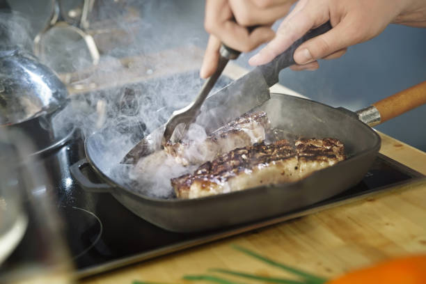 Cooking meat in a flying pan stock photo