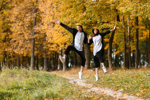 Photo of Couple in Matching Penguin Pajamas in autumn forest