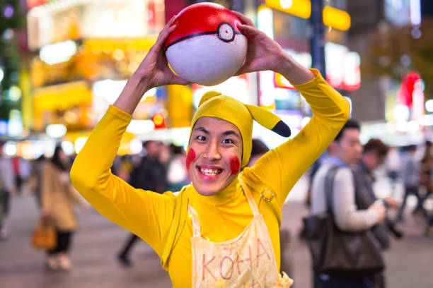 Man dressed up like Pikachu at Shibuya crosswalk in Tokyo, Japan TOKYO, JAPAN - NOVEMBER 12, 2016: Man dressed up like Pikachu at Shibuya crosswalk in Tokyo, Japan. Pikachu is a central character in the Pokémon anime series, famous in Japan. walking animation stock pictures, royalty-free photos & images