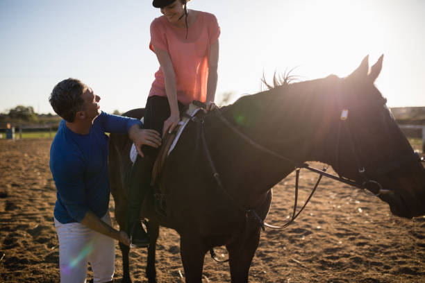istock Male trainer adjusting young woman leg on stirrup 838059272