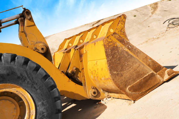 istock Yellow excavator on new construction site, with the bright sun and nice blue sky in the background 838062786