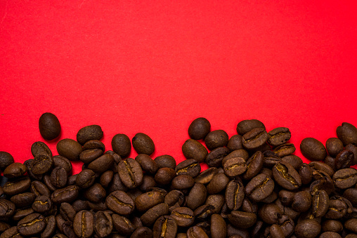 Coffee beans divided by red background.