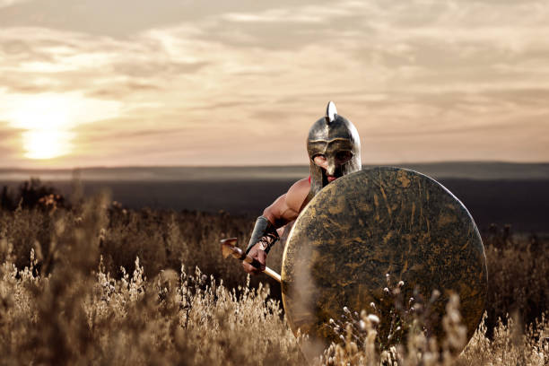 istock Soldier like spartan in bronze helmet holding  rounded shield. 838078392