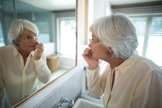 istock Senior woman checking her skin in mirror 838079122