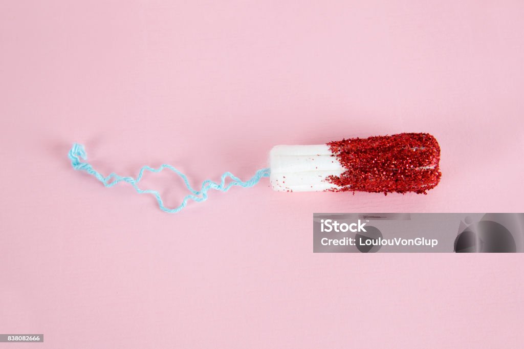 glitter stamp A hygienic tampon with red glitters instead of blood."nMinimal color still life and quirky photography Menstruation Stock Photo