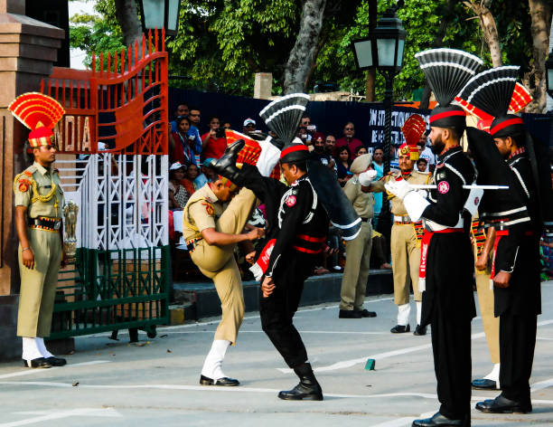 les gardes pakistanais et indien marches en uniforme national lors de la cérémonie d’abaisser les drapeaux sur la frontière entre le pakistan et l’inde, wagah, lahore, pakistan - closing ceremony photos et images de collection