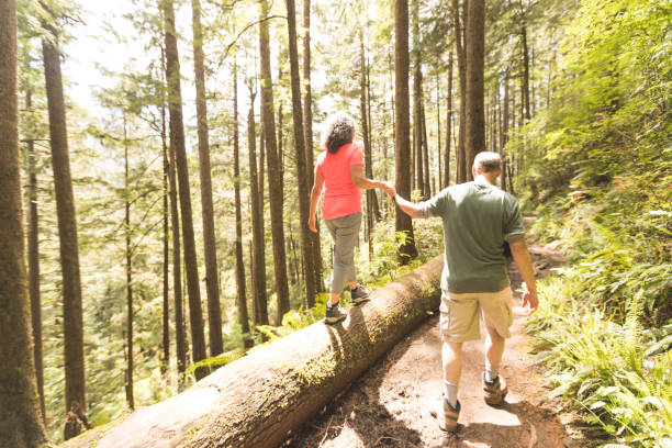 Woman hiking through the woods with a sunburst above her