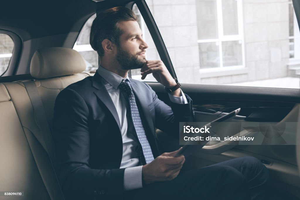 Young business man test drive new car Young business person test drive new vehicle usng digital device Luxury Stock Photo