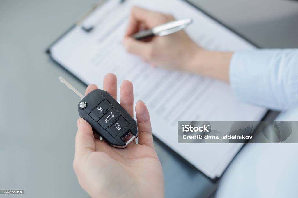 Young Woman in a Car Rental Service Assistant Concept Young woman assistant in a car rental service occupation Car Stock Photo