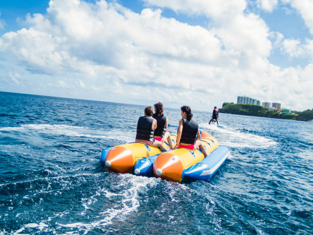 Three women riding a banana boat in guam