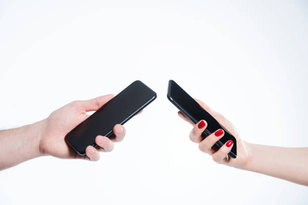 A couple holding their phones on white background