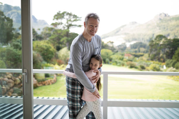istock Smiling father and daughter embracing each other in balcony 838106762