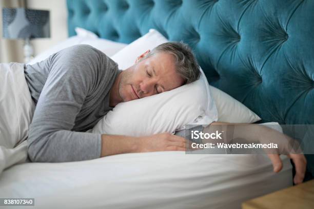 Man Sleeping On Bed In Bedroom Stock Photo - Download Image Now - Sleeping, Men, Bed - Furniture