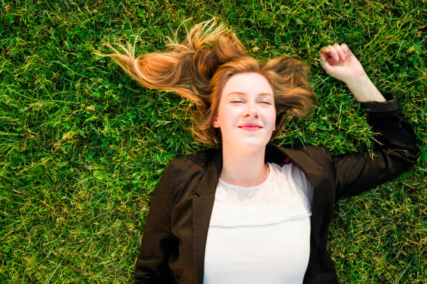 istock young independent woman relaxing on grass in park 838107708
