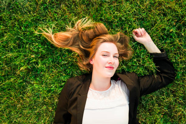 istock young independent woman relaxing on grass in park 838108032