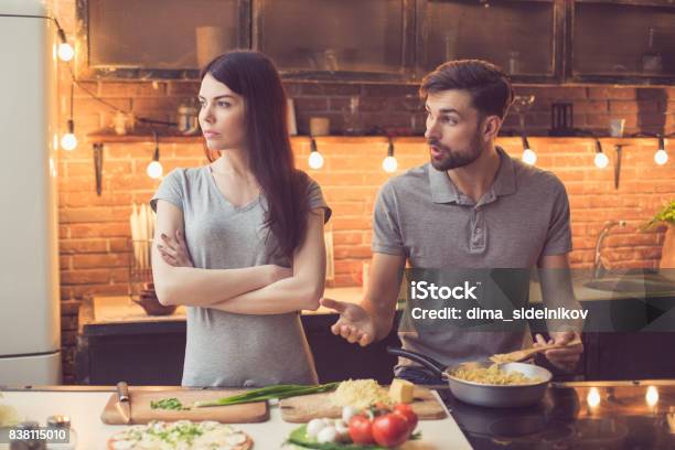 Young Couple Cooking In Kitchen Stock Photo - Download Image Now - Couple - Relationship, Arguing, Kitchen