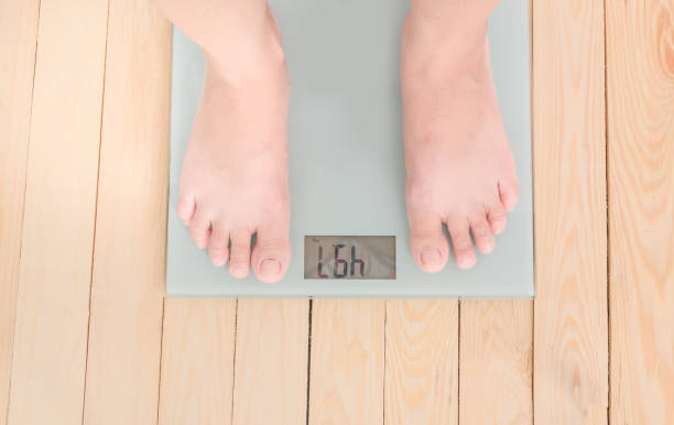 istock Low Section Of Overweight Person Standing On Weighing Scale 838117680