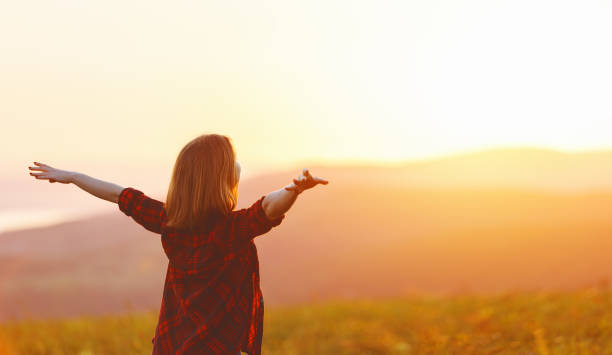 istock Happy woman standing with her back on sunset in nature iwith open hands 838117902