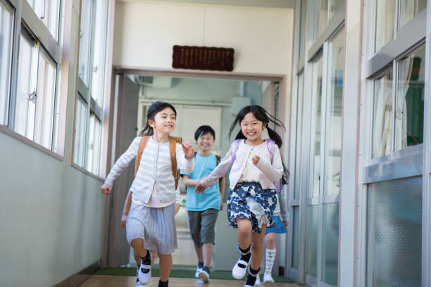 bambini delle scuole elementari che trasportano la borsa - randoseru foto e immagini stock