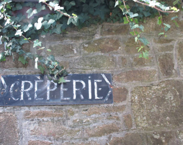 istock Creperie  Directional sign affixed to a stone wall 838144656