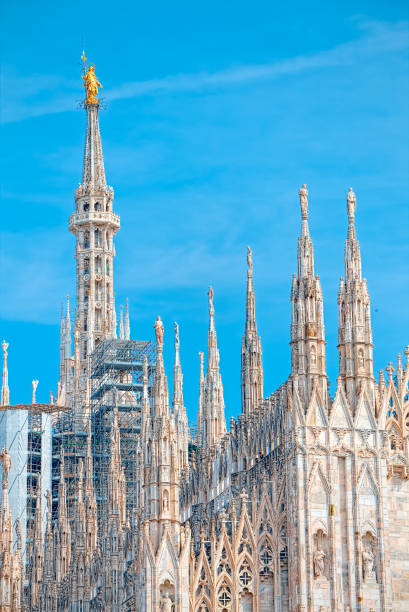 Details of the Milan Cathedral, the spiers and the Madonna Milan Cathedral is the cathedral church of Milan, Italy, dedicated to St Mary of the Nativity sentinel spire stock pictures, royalty-free photos & images