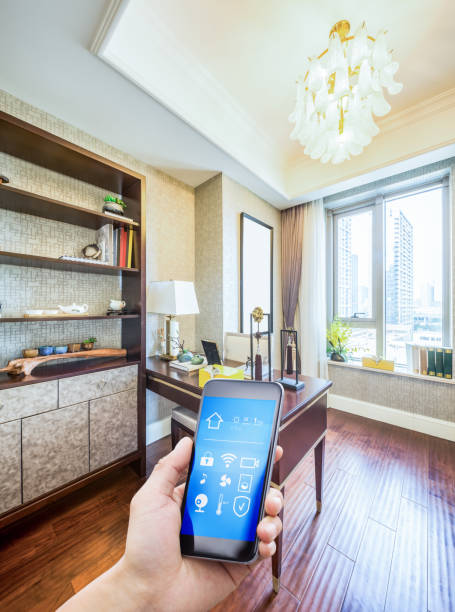 mobile phone in modern study mobile phone with smart home app in modern study smart thermostat photos stock pictures, royalty-free photos & images