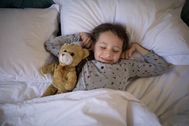istock Girl sleeping on bed with teddy bear in bedroom 838164272