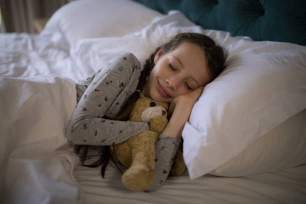 istock Girl sleeping on bed with teddy bear in bedroom 838164396