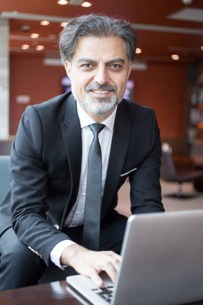 istock Smiling Business Man Working on Laptop in Lobby 838164656